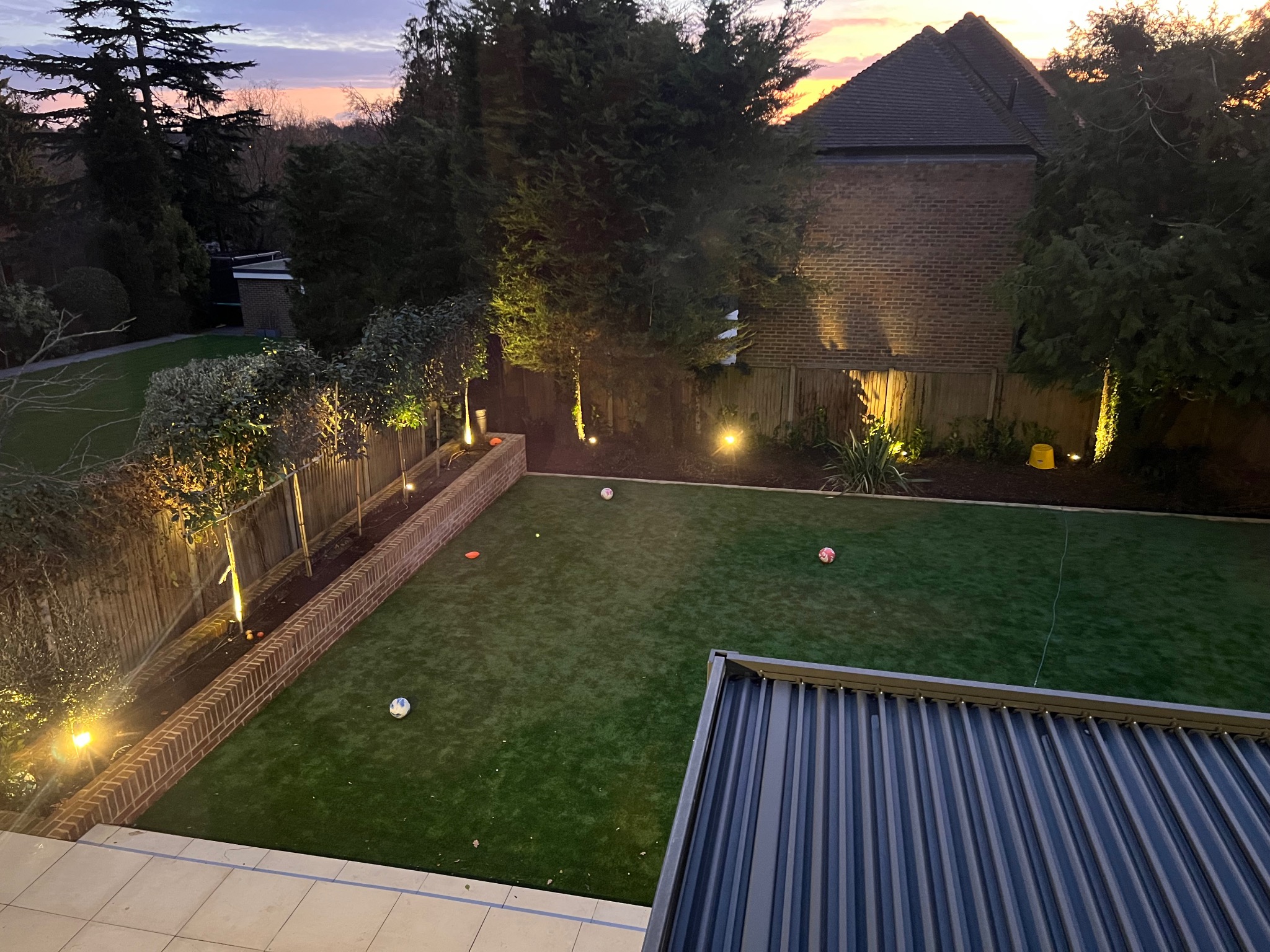 Garden lighting illuminating trees and boundary planting